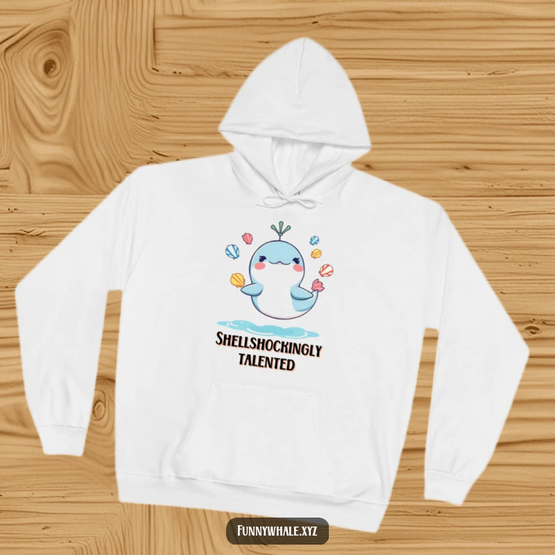 Funny hoodie depicting a mischievous whale juggling seashells, providing warmth and humor for ocean lovers, a great funny gift.